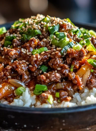 Close-up of Ground Beef Bulgogi served over white rice, garnished with sesame seeds and green onions